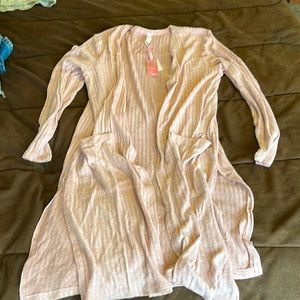 Rose gold long sleeve cardigan with pockets and split sides.